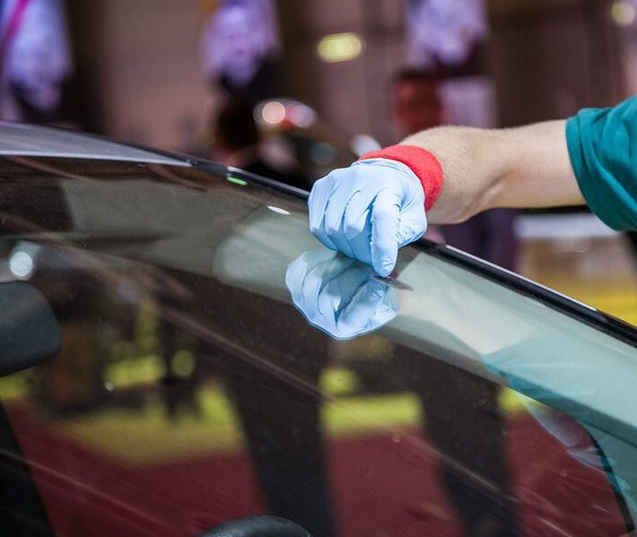 Technician fitting new auto glass